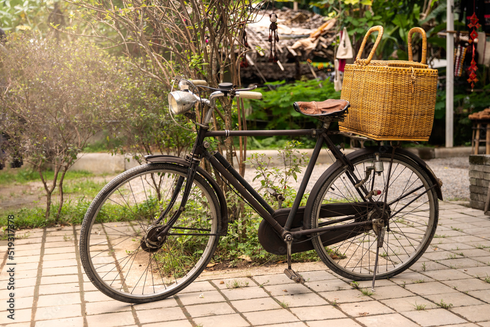 Vintage bicycle with a basketin front of a clothing store