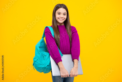 School girl hold laptop notebook on isolated studio background. Schooling and education concept. Teenager girl in school uniform.