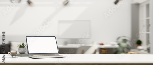 White workspace with open laptop mockup and copy space over blurred modern office background