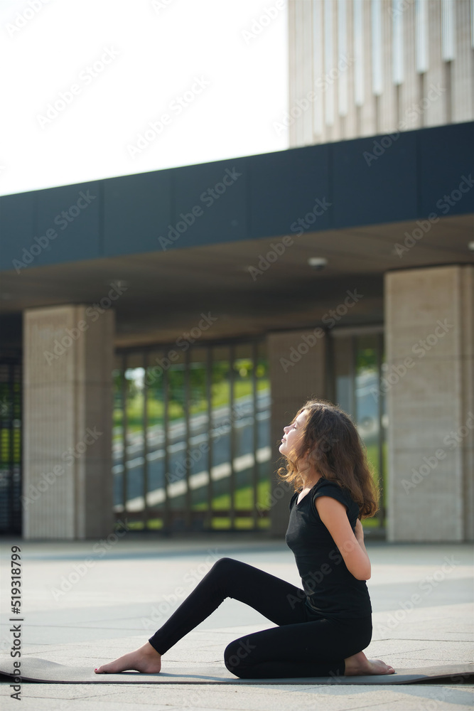 Girl doing yoga school age in sports form shows the elements of sports and asanas. Girl doing yoga school age in sports form shows the elements of sports and asanas.
