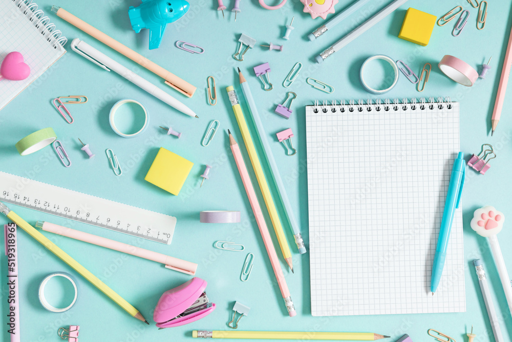 Back to school background. Flat lay, top view of colorful scattered stationery on isolated pastel blue table background. School supplies on desk. Copyspace. Back to school background. Flat lay, top view of colorful scattered stationery on isolated pastel blue table background. School supplies on desk. Copyspace.