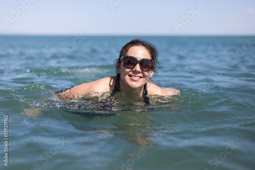 Happy pregnant woman on sea vacation. Future happy mother bathes in warm sea water