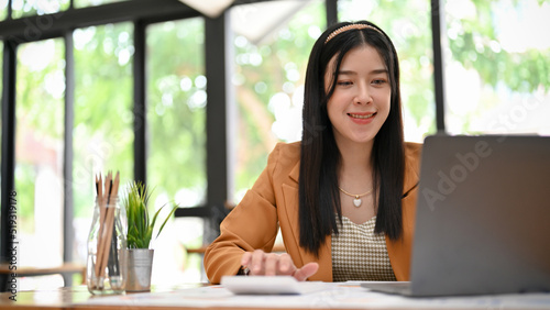 Free Download Beautiful Asian female accountant or financial worker working on her financial task on laptop. - GFXLoad