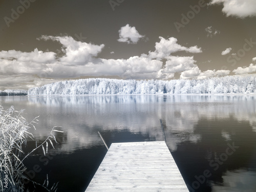 Tela infrared surreal landscape, lake with wooden footbridge, infrared photo snowy tr
