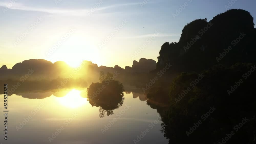 Magical misty lake with Limestone mountains at sunrise with motion mist. Nong Thale lake in Krabi, Thailand - the famous travel destination in south of Siam or Thailand. Magical misty lake with Limestone mountains at sunrise with motion mist. Nong Thale lake in Krabi, Thailand - the famous travel destination in south of Siam or Thailand.