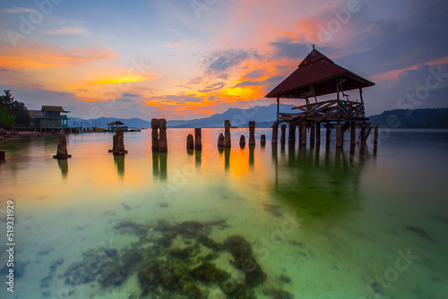 stunning sunset on the beach Tanjung Putus Lampung. building on a clear sea under a sunset. Indonesian landscapes tropical beaches.