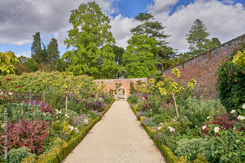 Canvastavla Walled garden with gravel path and traditional herbacious perennial planting in