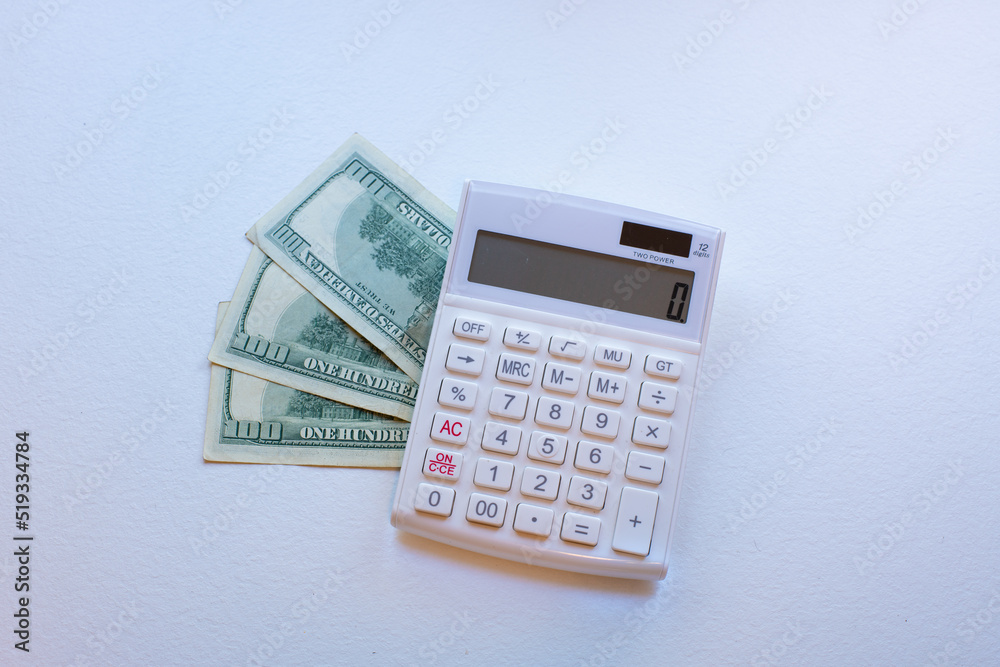 Dollar. Dollar banknotes with a green calculator on the desk. Global business and foreign exchange market concepts. Dollar. Dollar banknotes with a green calculator on the desk. Global business and foreign exchange market concepts.