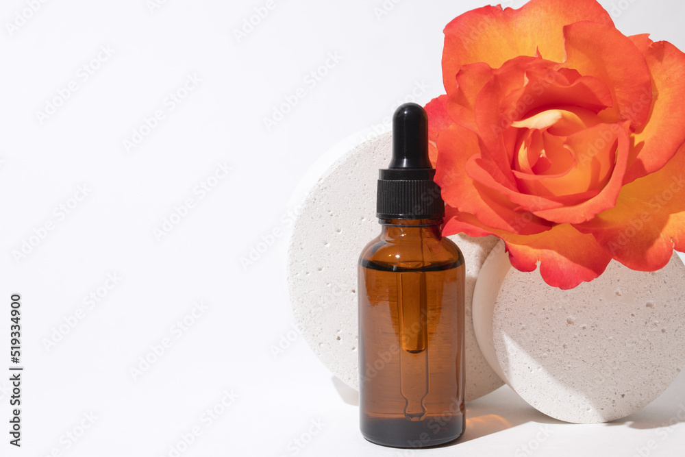 Glass dropper bottle with rose flower. Hyaluronic acid oil, serum with collagen and peptides skin care product. Mockup packaging, cosmetic design branding Glass dropper bottle with rose flower. Hyaluronic acid oil, serum with collagen and peptides skin care product. Mockup packaging, cosmetic design branding