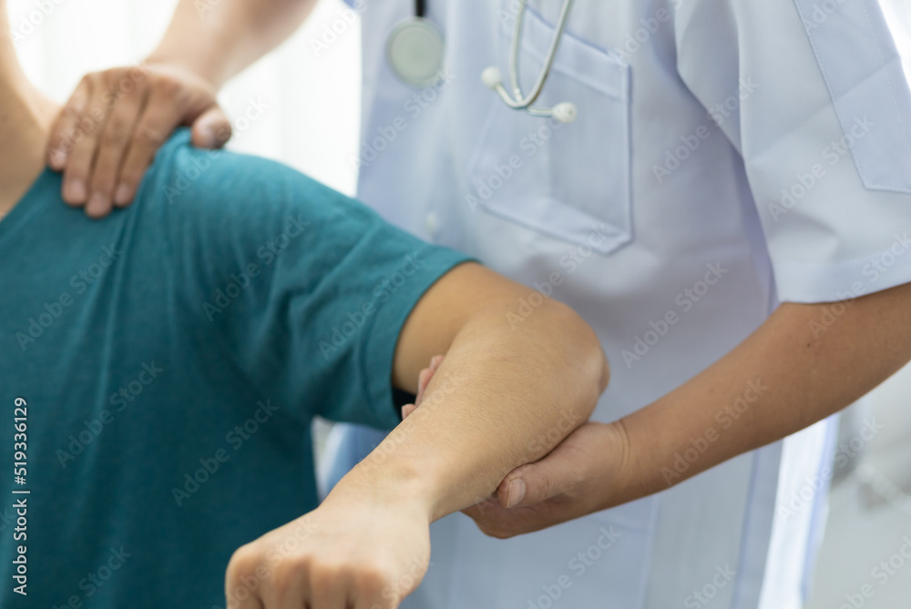 Concept of physical therapy and rehabilitation. A man with shoulder pain goes to the doctor, The doctor diagnoses the patient's arm pain and shoulder pain. Concept of physical therapy and rehabilitation. A man with shoulder pain goes to the doctor, The doctor diagnoses the patient's arm pain and shoulder pain.