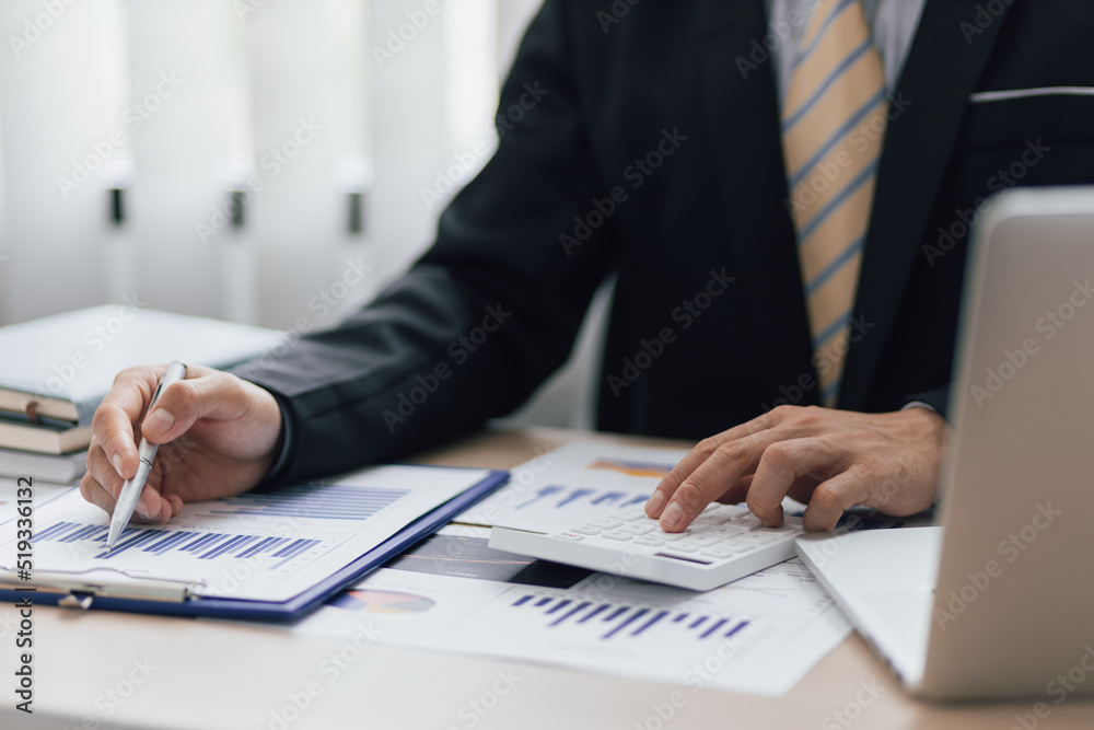 Close up a man working about financial with calculator at his office to calculate expenses, Accounting Concepts and Financial Planning Close up a man working about financial with calculator at his office to calculate expenses, Accounting Concepts and Financial Planning