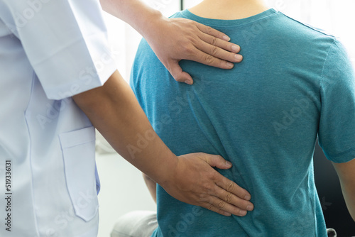 Vászonkép A man with back pain sees a doctor so the doctor is diagnosing men's back pain and shoulder pain