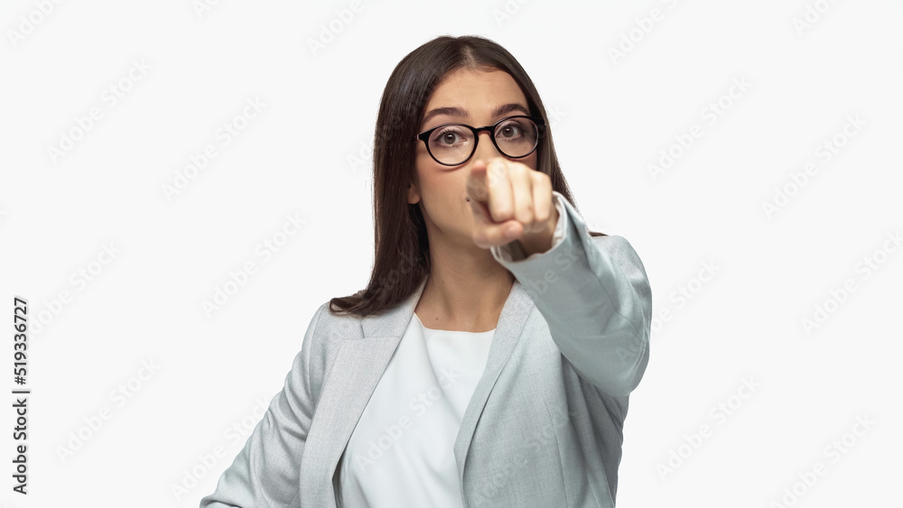 young businesswoman in grey blazer and eyeglasses pointing with finger isolated on white. young businesswoman in grey blazer and eyeglasses pointing with finger isolated on white.