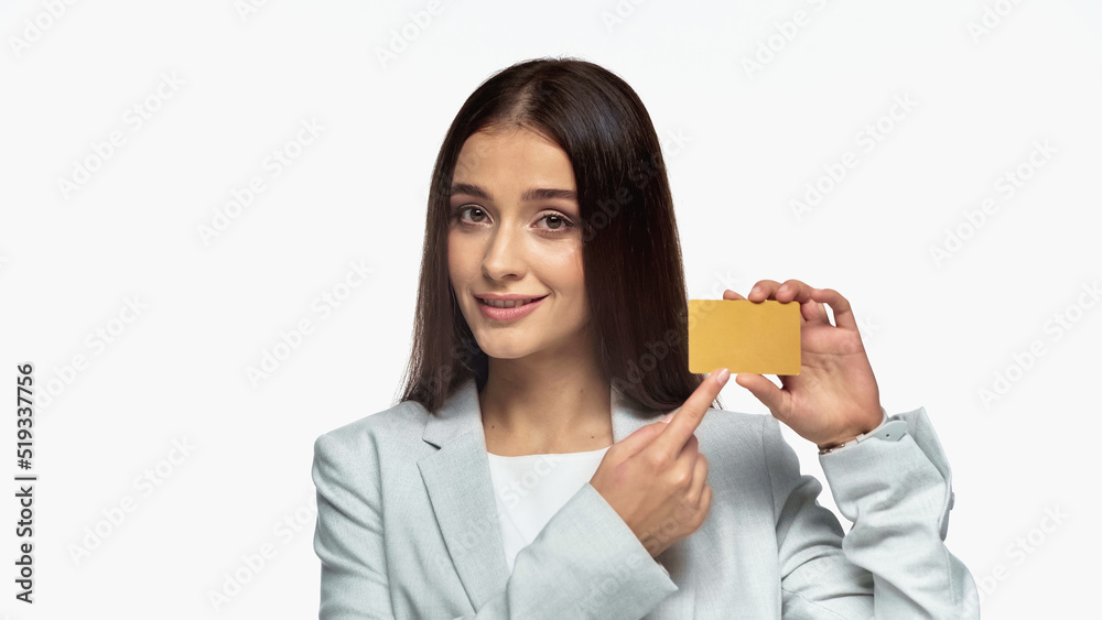 successful businesswoman in grey blazer smiling and pointing at credit card isolated on white. successful businesswoman in grey blazer smiling and pointing at credit card isolated on white.
