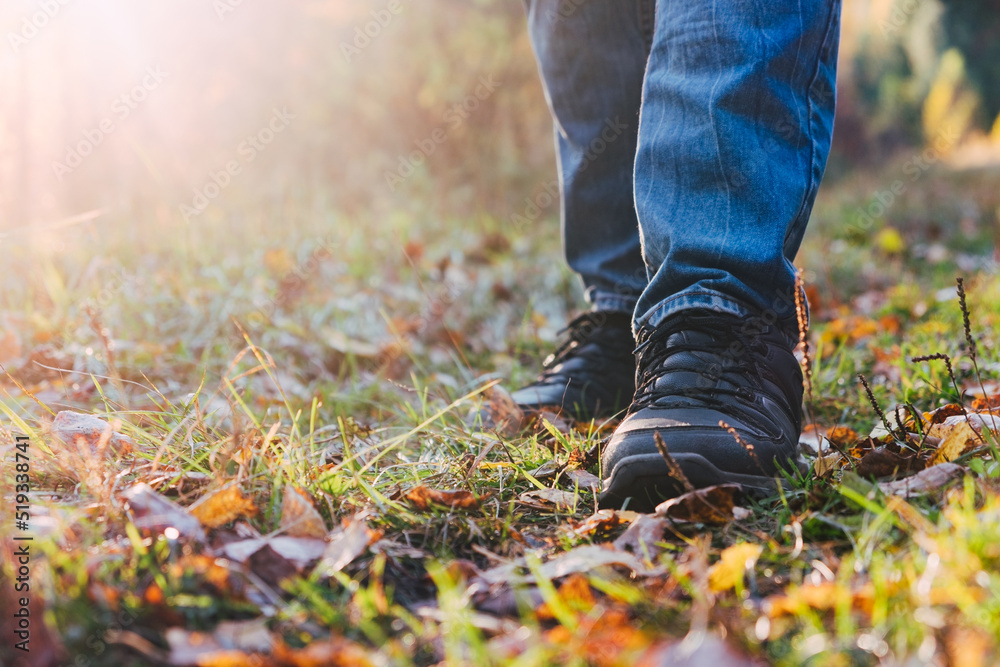 Man wearing shoes close up in autumn forest during hiking trip. Fall season, travel concept. Background with copy space for text Man wearing shoes close up in autumn forest during hiking trip. Fall season, travel concept. Background with copy space for text