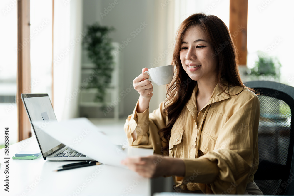 Portrait of smiling beautiful business asian woman with working in modern office desk using computer, Business people employee freelance online marketing e-commerce chart analysis concept.