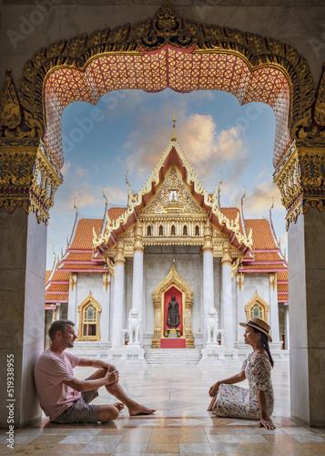 Wat Benchamabophit temple in Bangkok Thailand, The Marble temple in Bangkok. Asian woman with hat and European men visiting a temple, a couple on a city trip in Bangkok photo