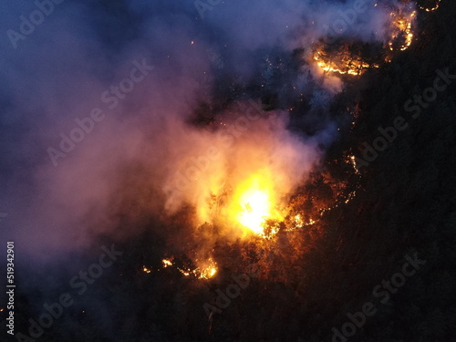 Aerial panoramic view of a forest fire at night  heavy smoke causes air pollution  and fire in full blaze. Natural disaster epic drone cinematic shot.