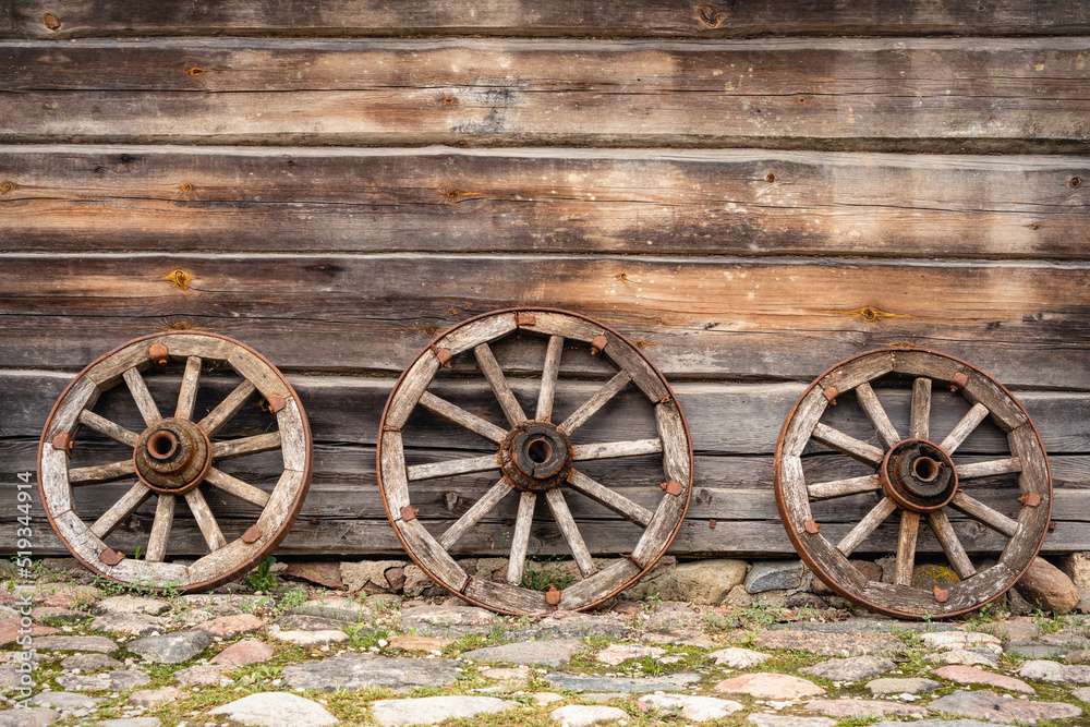 Three old wooden wagon wheels
