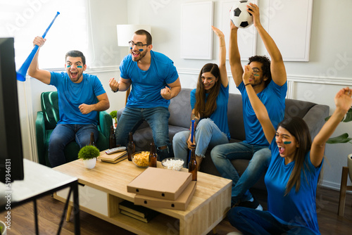 Excited friends cheering after winning soccer championship photo