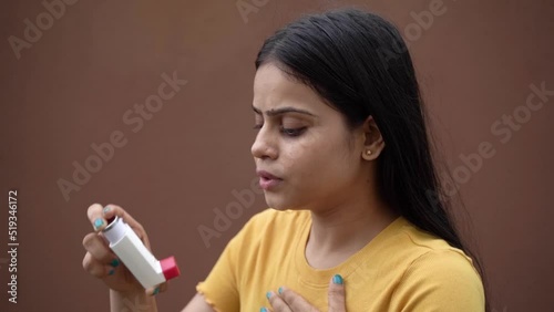 Asthmatic patient catching inhaler having an asthma attack. Young woman having asthma, chronic obstructive pulmonary disease photo