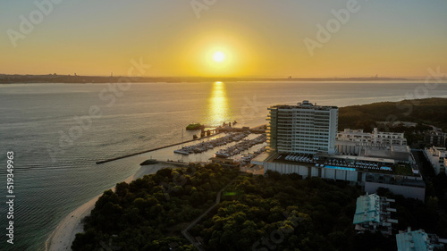 huge sunrise in Troia Peninsula, Setubal, Portugal on a sunny day, near Lisbon. Ferry working on the river sado.