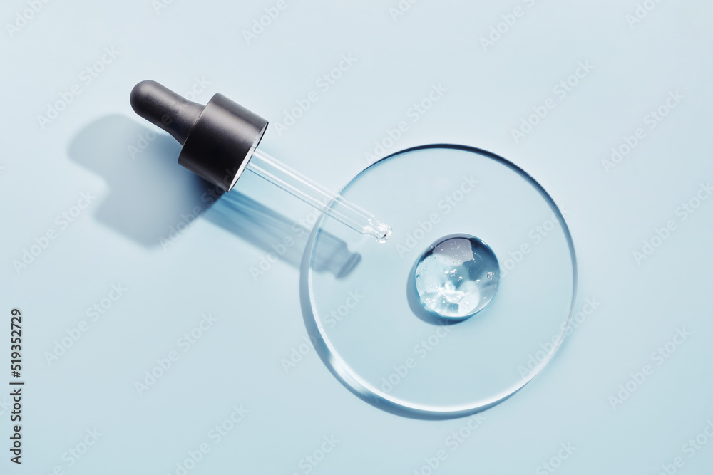 Pipette with sample of gels cosmetic product in petri dish on blue background, hard shadows