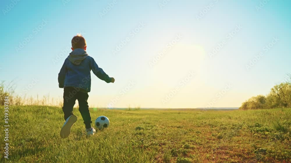cute little boy is playing football in field in nature in sunny summer day, slow motion, funny preschooler child is running and kicking soccer ball, happy childhood moments cute little boy is playing football in field in nature in sunny summer day, slow motion, funny preschooler child is running and kicking soccer ball, happy childhood moments