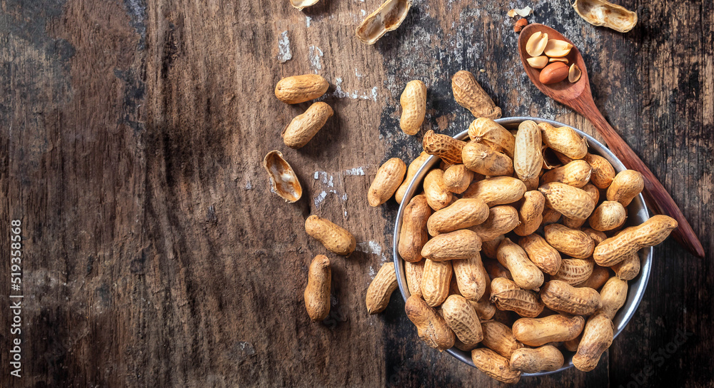 Dried peanuts or nuts on wooden background.Peanut shells on a wooden spoon Dried peanuts or nuts on wooden background.Peanut shells on a wooden spoon