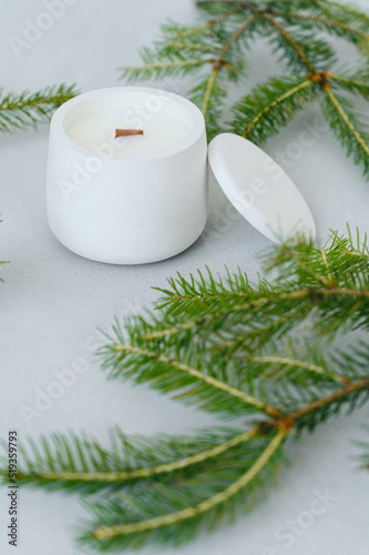 Candle in White Gypsum Planter Among Christmas Tree Branches on Light Background. Place on Label © maxfotoadobe