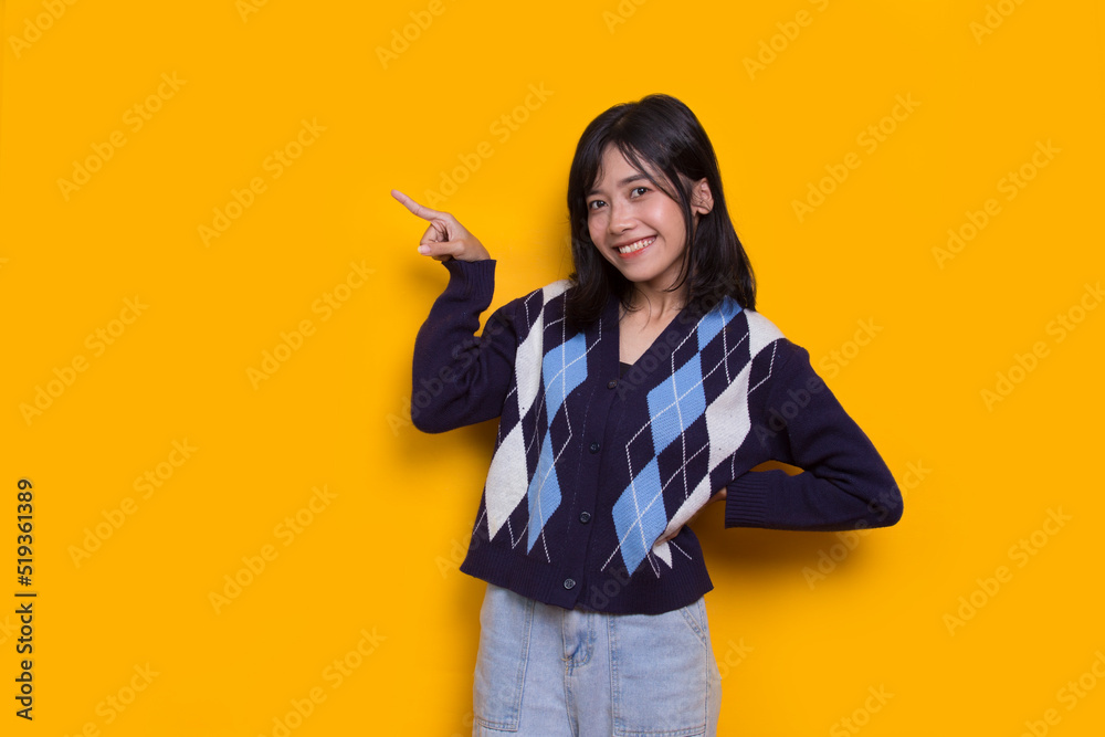 young asian woman pointing with fingers to different directions isolated on yellow background young asian woman pointing with fingers to different directions isolated on yellow background