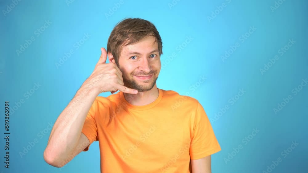 Portrait of smiling young man looking at camera and making call me gesture. Call me back. Portrait of smiling young man looking at camera and making call me gesture. Call me back.