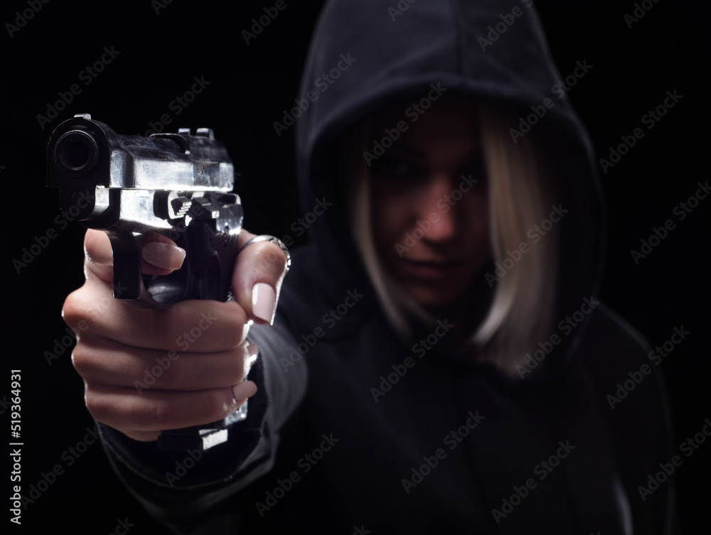 Young woman shooting with gun on the street at night Young woman shooting with gun on the street at night
