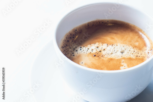 Hot americano coffee in a white cup isolated on a white table.