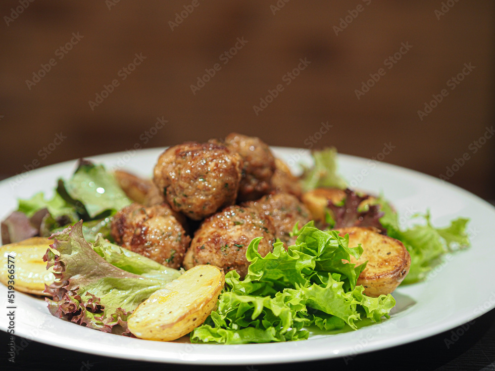 Dish of meatballs with potatoes and salad Dish of meatballs with potatoes and salad