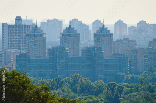 Amazing aerial cityscape of Kyiv in morning haze. Silhouettes of modern high-rise buildings at smog. Concept of modern architecture from glass  steel and concrete. High-rise houses at smoke