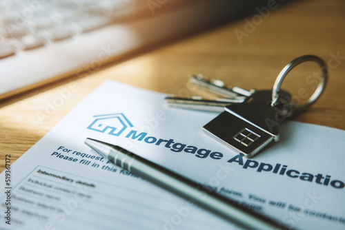 Foto mortgage loan application document and new house keys on the bank office table