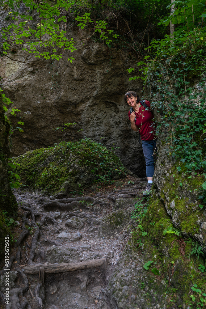 Wanderin in der Bürserschlucht, wandernde Frau neben den steilen Felswänden auf dem schmalen Weg durch die bewaldete Schlucht. bei Bürs in Vorarlberg, Österreich Wanderin in der Bürserschlucht, wandernde Frau neben den steilen Felswänden auf dem schmalen Weg durch die bewaldete Schlucht. bei Bürs in Vorarlberg, Österreich