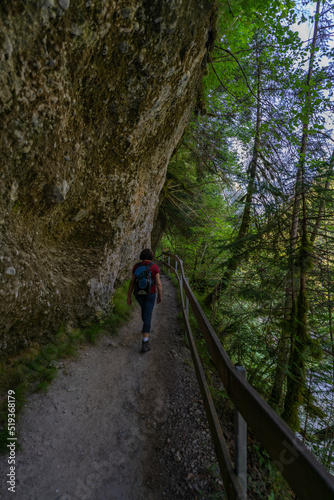 Wanderin in der Bürserschlucht, wandernde Frau neben den steilen Felswänden auf dem schmalen Weg durch die bewaldete Schlucht. bei Bürs in Vorarlberg, Österreich photo