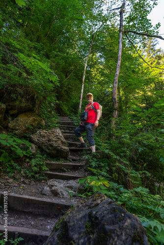 Wanderer auf dem Weg durch die Bürser Schlucht, Mann auf dem schmalen Wanderweg über Treppen und Stufen durch die bewaldete Schlucht bei Bürs, Vorarlberg, Österreich