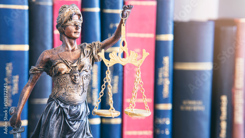 Fotografie Scales of justice in front of book background