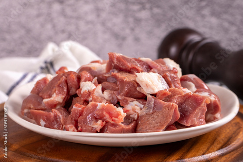 Lamb cubed meat. Chopped red meat in a plate on a stone floor. Butcher products. close up