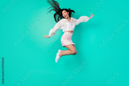 Full body photo of cheerful lady excited jump high active moving isolated cyan color background