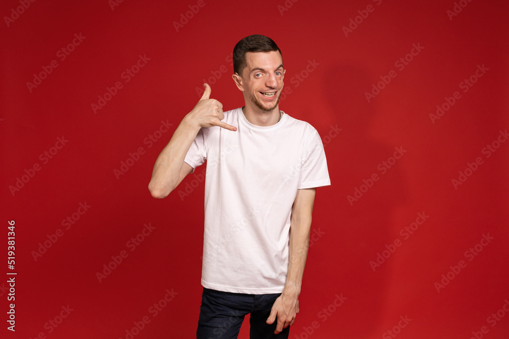 A young man in a white T-shirt gestures to the bell A young man in a white T-shirt gestures to the bell