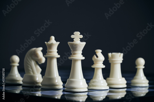 All suits white chess pieces on chess board.