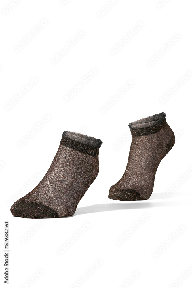 Close-up shot of black transparent glitter mesh ruffle trim socks. The pair of ruffle ankle lurex socks is isolated on a white background. Side view. Close-up shot of black transparent glitter mesh ruffle trim socks. The pair of ruffle ankle lurex socks is isolated on a white background. Side view.
