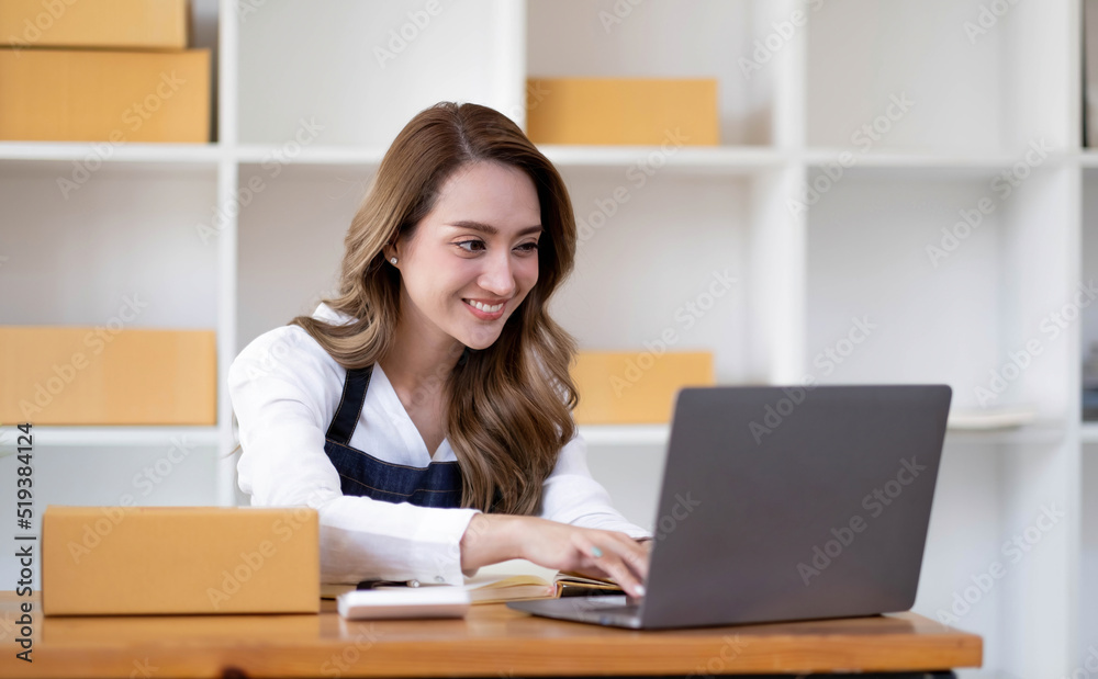 Portrait of Asian young woman SME working with a box at home the workplace.start-up small business owner, small business entrepreneur SME or freelance business online and delivery concept. Portrait of Asian young woman SME working with a box at home the workplace.start-up small business owner, small business entrepreneur SME or freelance business online and delivery concept.