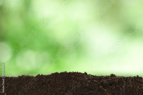 Ground soil or foreground surface isolated on blurred green natural background. Space for advertisements and products.