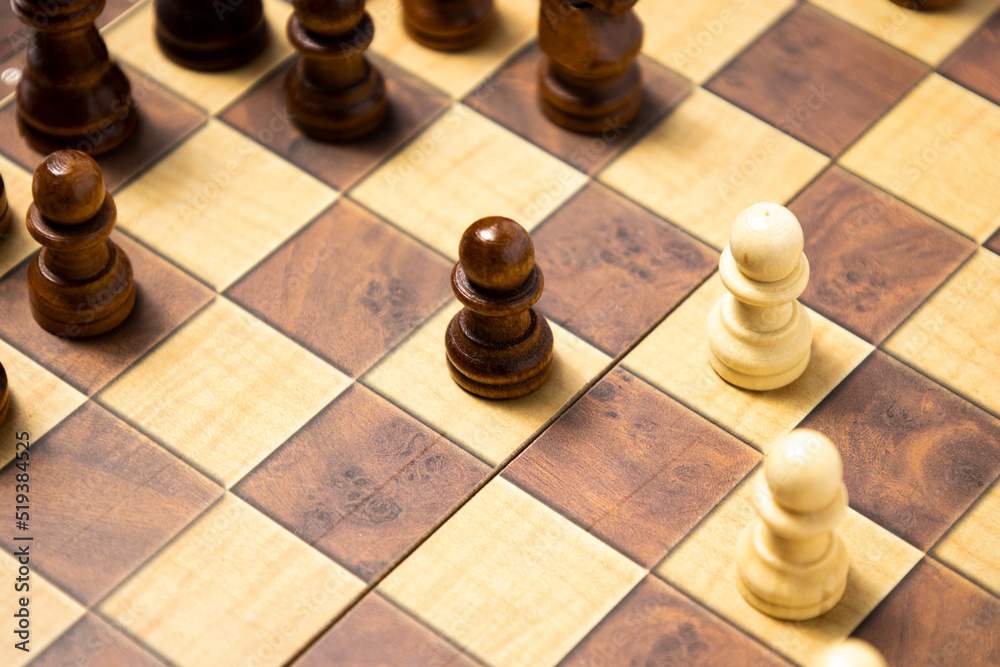 Wooden chess pieces are arranged on a wooden board. Top view, flat lay Wooden chess pieces are arranged on a wooden board. Top view, flat lay
