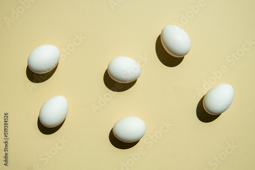 Chicken white eggs on a light sandy background. Top view, flat lay